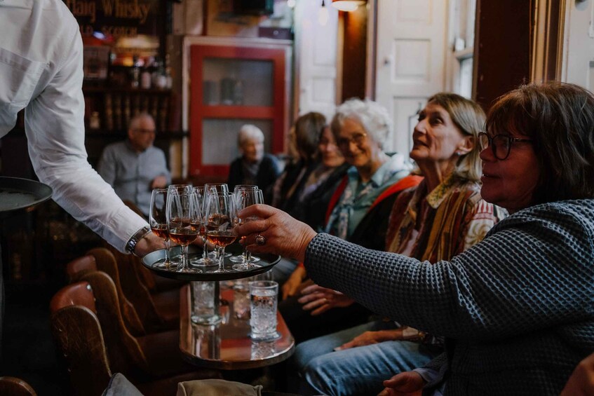 A person serving drinks to a group of people at a bar. 5