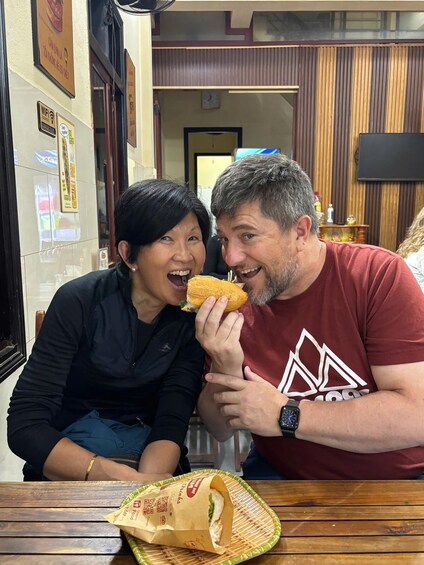 Two people sitting at a wooden table in a restaurant. 2