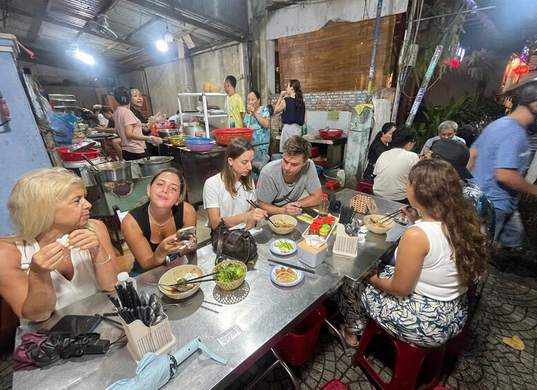 A group of people dining at a restaurant with various dishes and utensils on the table. 5