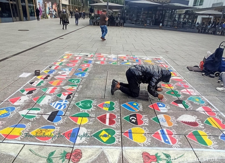 A person drawing flags on the ground in a public square. 2