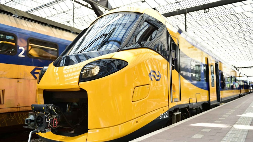 A yellow and blue train at a station platform. 3