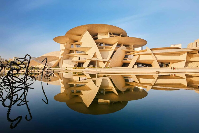 A modern architectural building with a unique, layered design, reflecting in a calm body of water. 3