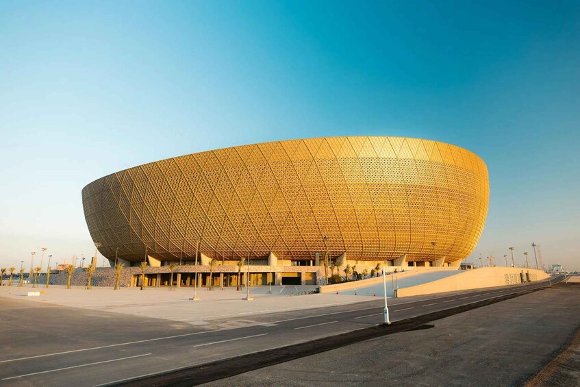 A large, uniquely shaped stadium with a golden exterior. 5