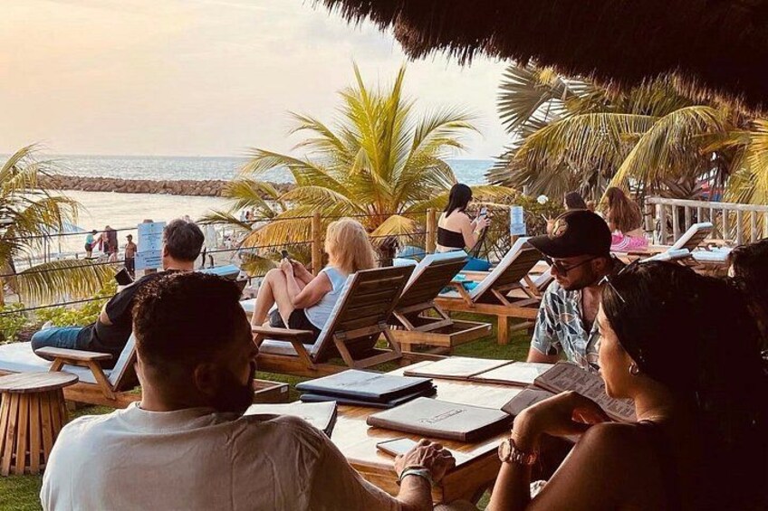 Un espace de détente aménagé au bord de la plage, où l’on peut se relaxer sur des chaises longues tout en admirant l’océan. 2
