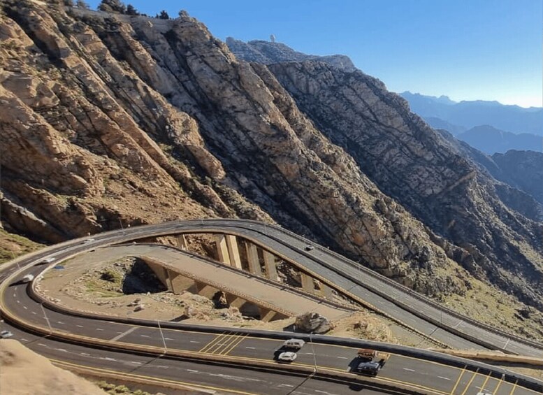 A winding mountain road with vehicles. 2