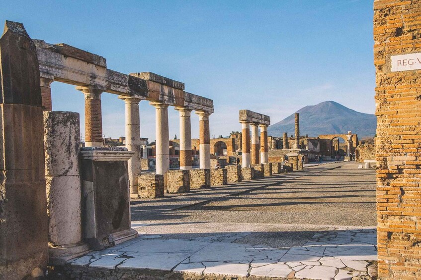 Ancient ruins with columns and a mountain in the background. 2