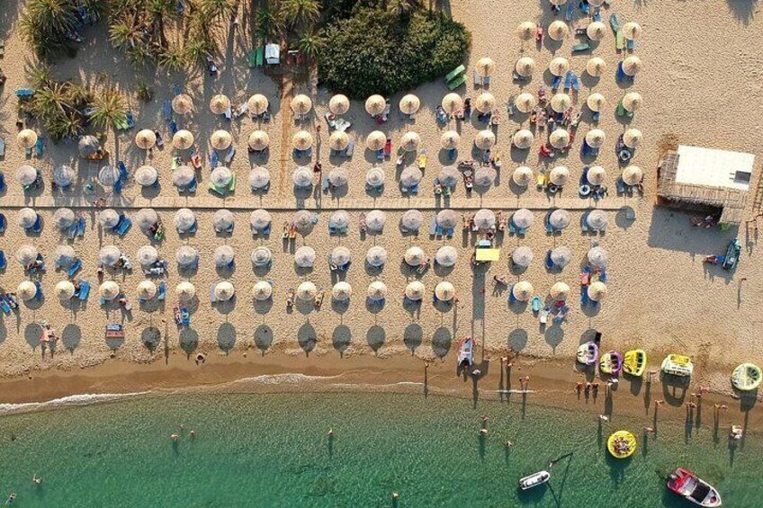 An aerial view of a beach with rows of umbrellas and people. 2