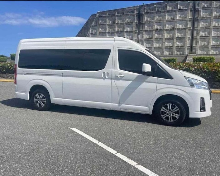 A white van parked in a lot with a large building in the background. 5