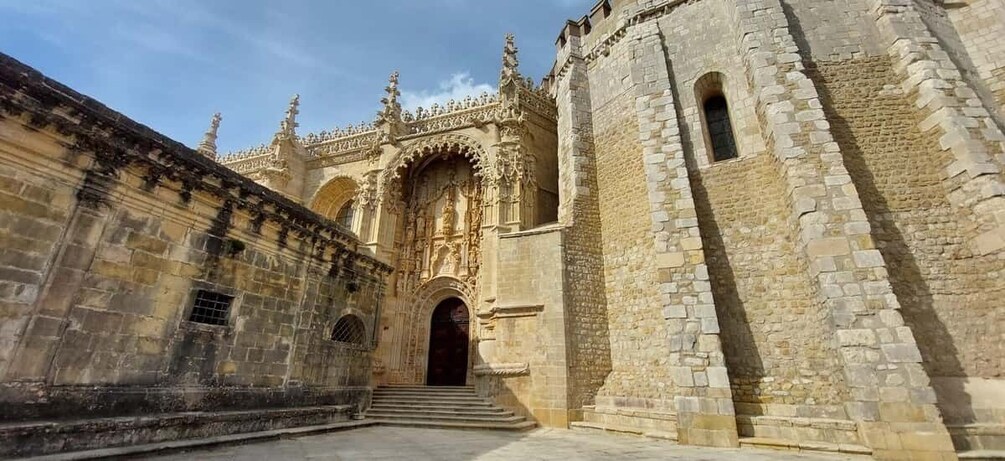 A historic building with ornate Gothic architecture, featuring a large arched entrance and detailed stonework. 5