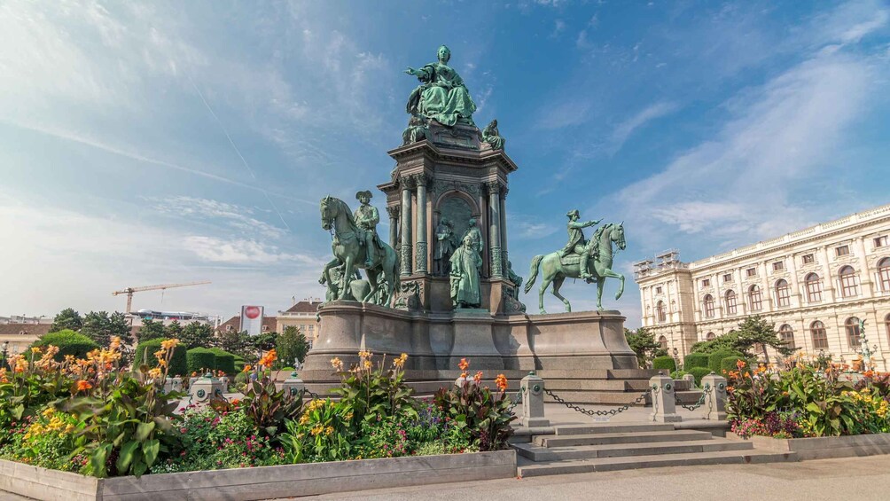 A statue of a man on horseback surrounded by flowers. 3
