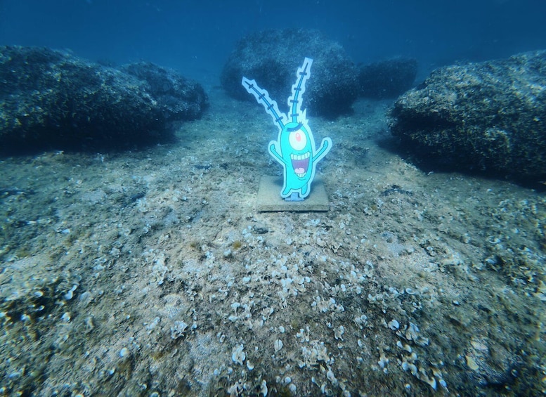 An underwater scene with a cartoon character on a stand. 3