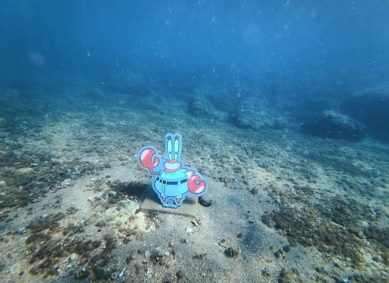 An underwater scene with a cartoon character on the ocean floor. 2