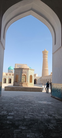 A courtyard with a tall minaret and a building with intricate tile work. 3