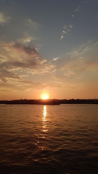 A sunset over a body of water with a city skyline in the background. 4