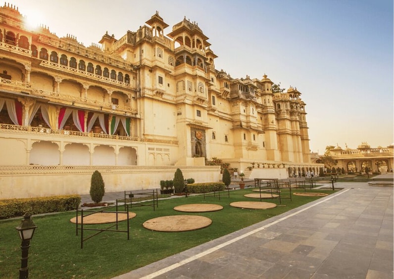 A grand palace with intricate architecture, a well-maintained garden, and a clear sky. 1
