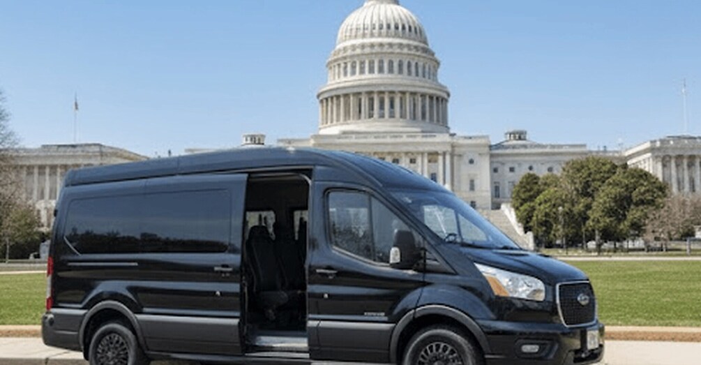 A black van parked in front of a large white building with a dome. 4