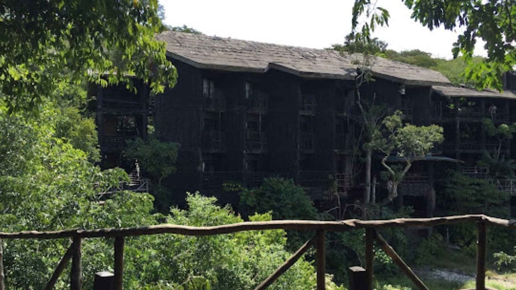 A traditional wooden building surrounded by lush greenery. 5