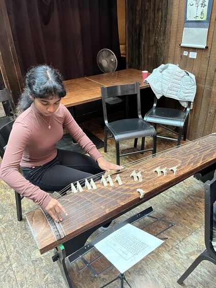 A person playing a traditional stringed instrument. 4