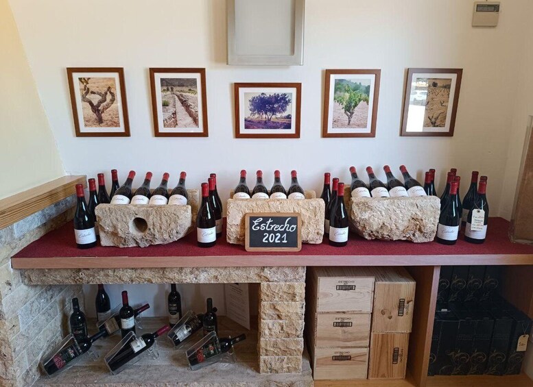 A wine display with bottles and framed pictures on a counter. 3