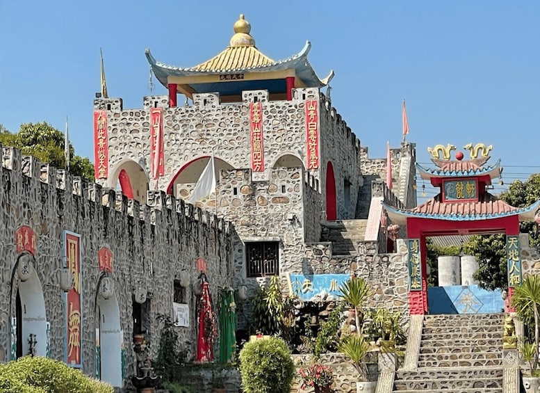 A traditional Chinese building with a stone facade, red banners, and a decorative roof. 4