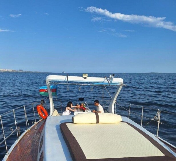A boat with a white deck, a life preserver, and a flag. 1