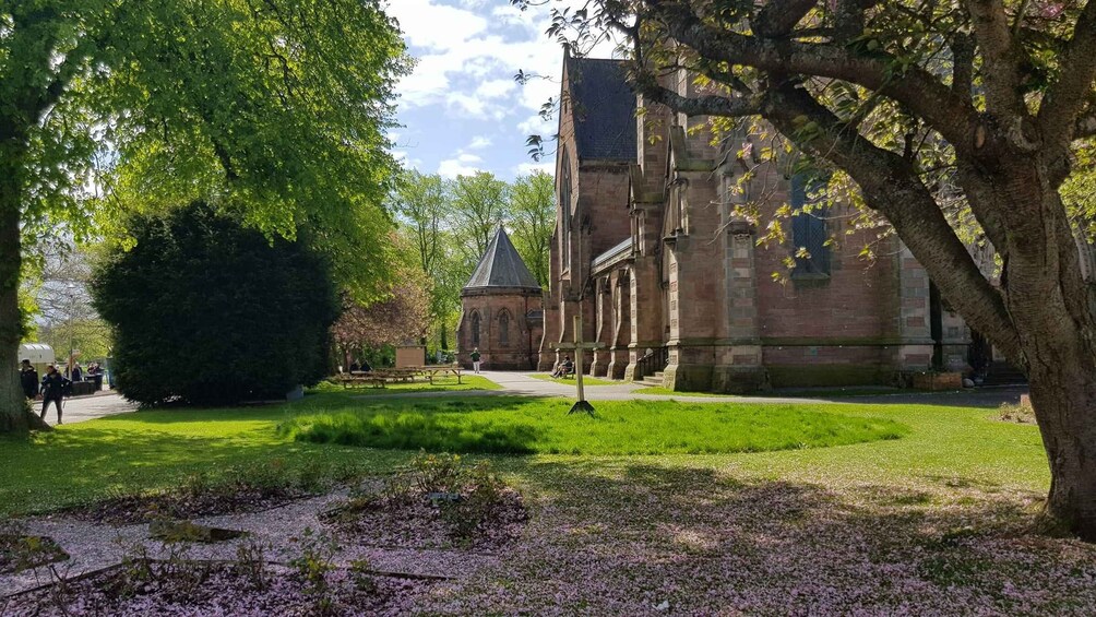 A historic building with a tower, surrounded by lush green grass and trees. 5