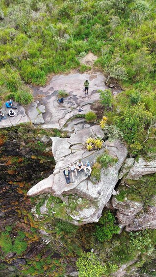 A group of hikers on a rocky trail surrounded by lush greenery. 1