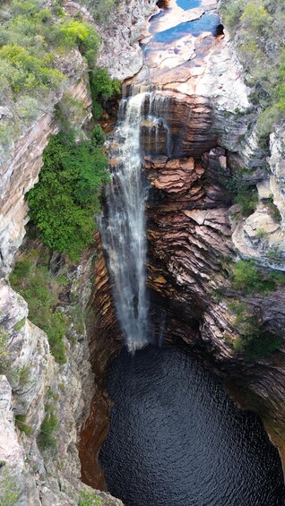 A waterfall cascading down a rocky cliff into a pool below. 2