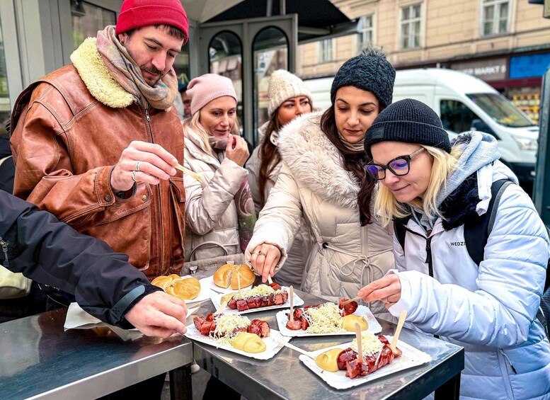People eating hot dogs at an outdoor food stall. 2