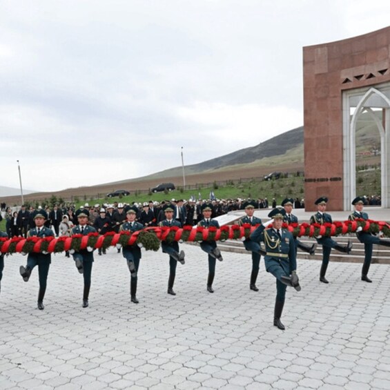 A ceremonial wreath-laying with uniformed personnel in a public square. 3