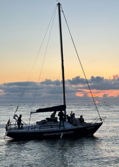 A sailboat named 'MORGAN' with people on deck, sailing on calm waters during sunset. 5