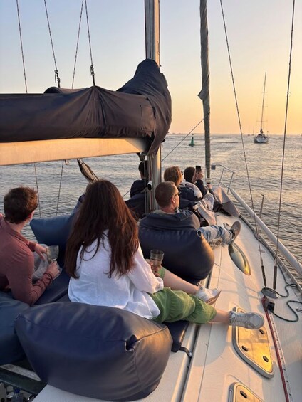 People relaxing on a sailboat with a sunset in the background. 1