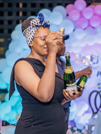 A person holding a bottle of champagne. 2