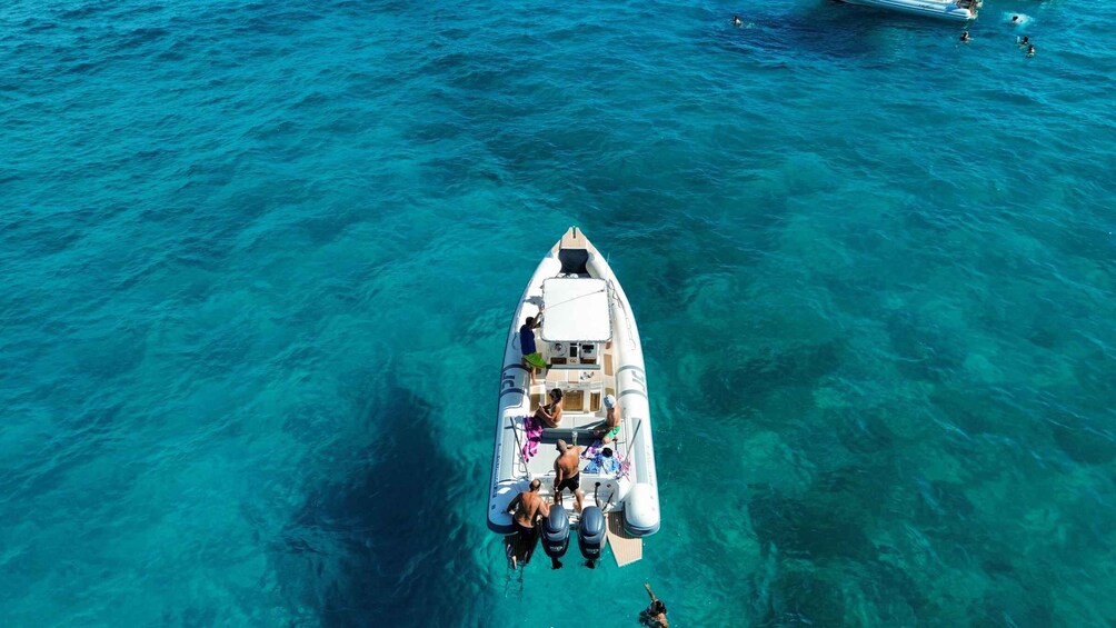 Un bote con pasajeros navegando en aguas azules y transparentes. 1