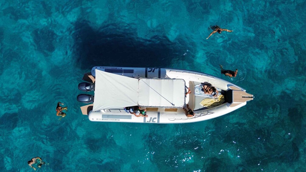 Un bote con gente a bordo y otras personas nadando alrededor. 3