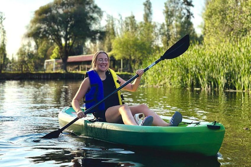 Una persona haciendo kayak en un río tranquilo rodeado de vegetación. 4