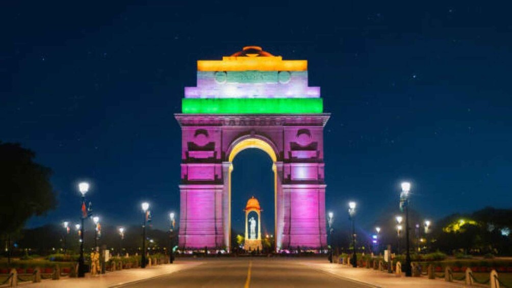 The India Gate at night, illuminated with vibrant colors. 5