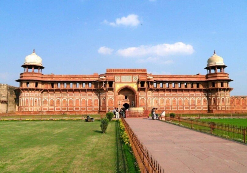 A large, historic building with two domed towers and an arched entrance. 2