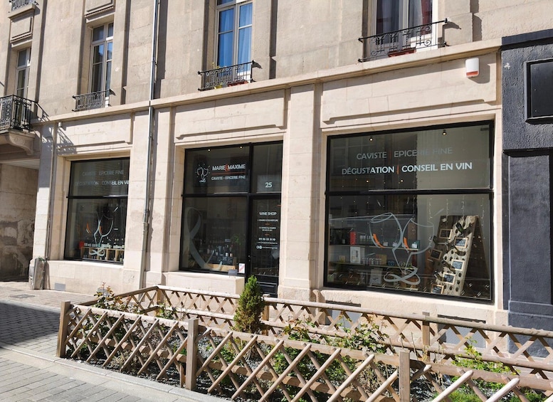 A storefront with large windows displaying wine bottles and a sign reading 'CAVISTE EPICERIE FINE.' 3