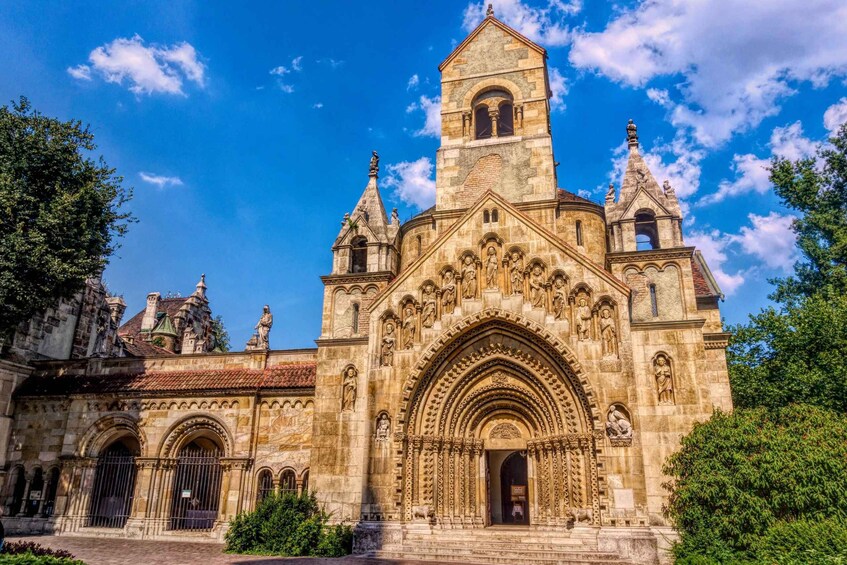 A historic cathedral with intricate stone carvings, a prominent bell tower, and statues. 4