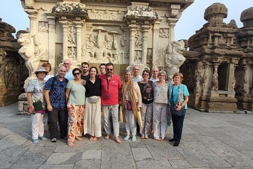 A group of people standing in front of a temple with intricate carvings. 2