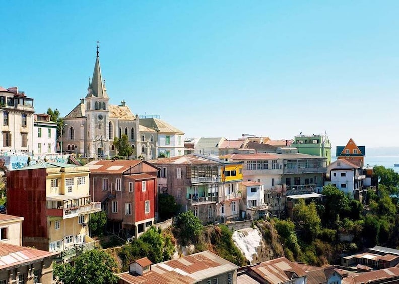 A coastal town with colorful buildings, a prominent church, and a clear blue sky. 3