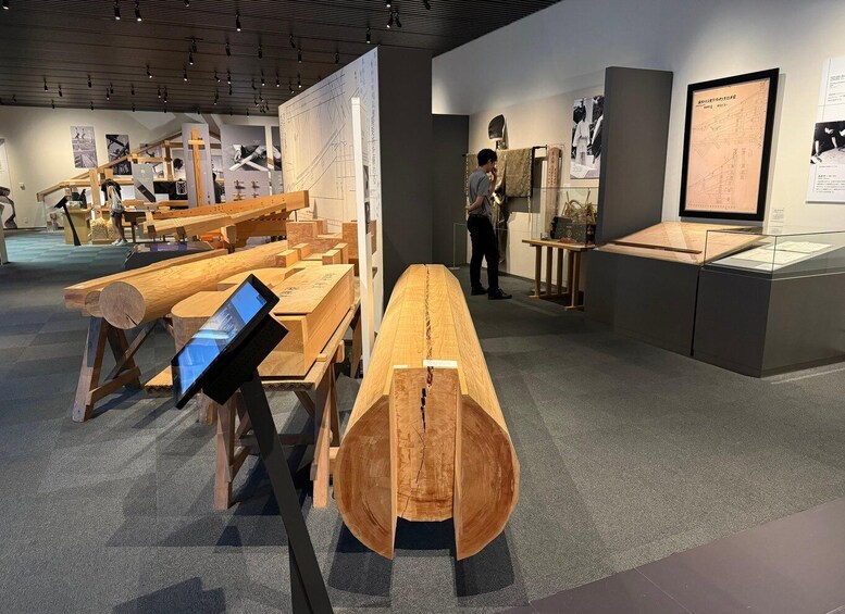 A museum exhibit with wooden sculptures and architectural drawings. 3