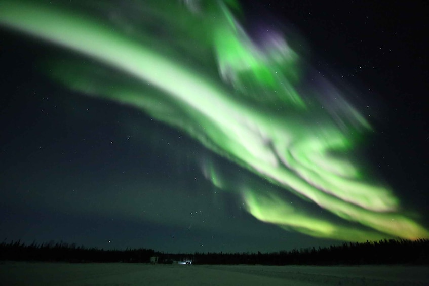 The Northern Lights over a snowy landscape at night. 5