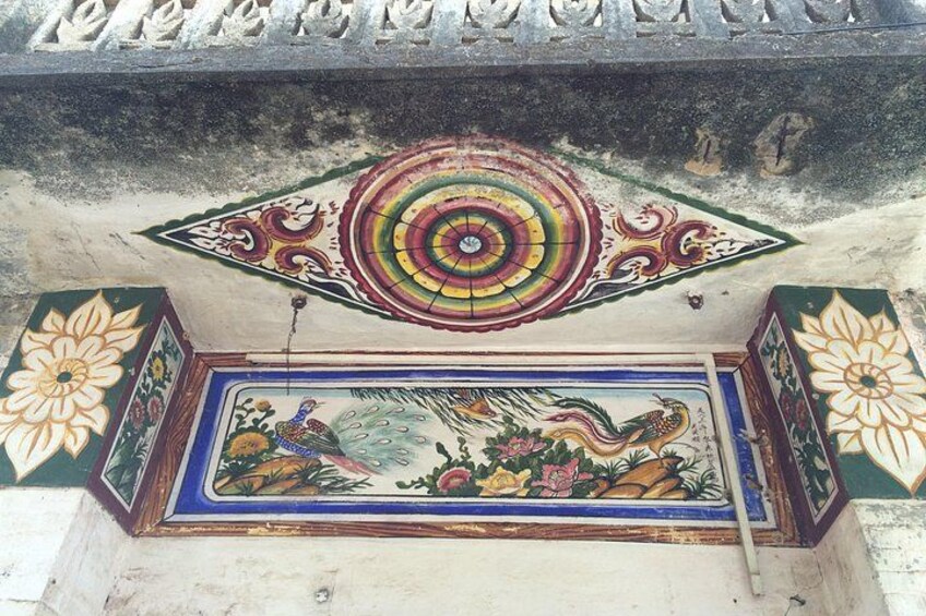 A colorful mural with peacock designs and a central circular pattern. 3