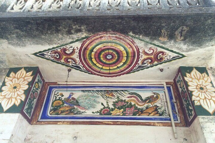 A colorful mural with peacocks and floral patterns on a wall. 4