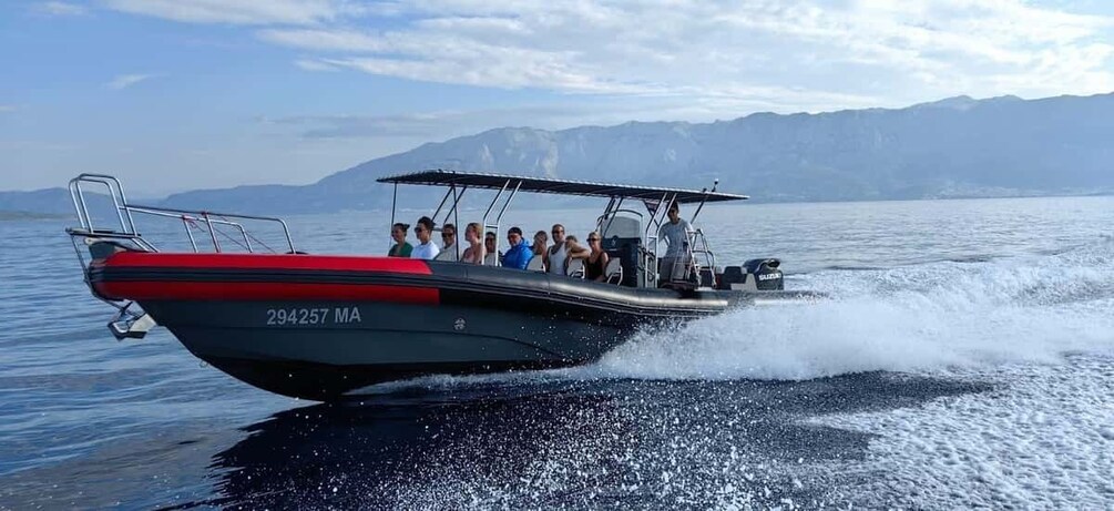 A boat with passengers, moving on a lake with mountains in the background. 1