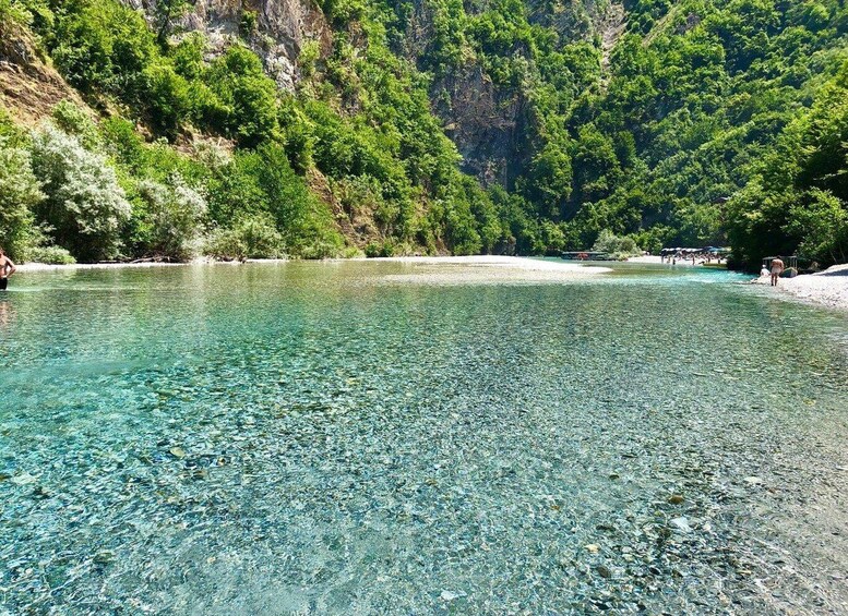 A clear lake surrounded by forested hills. 2