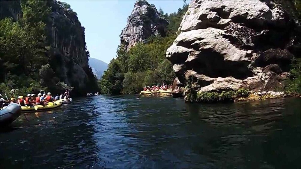 A river with people rafting in yellow boats. 5