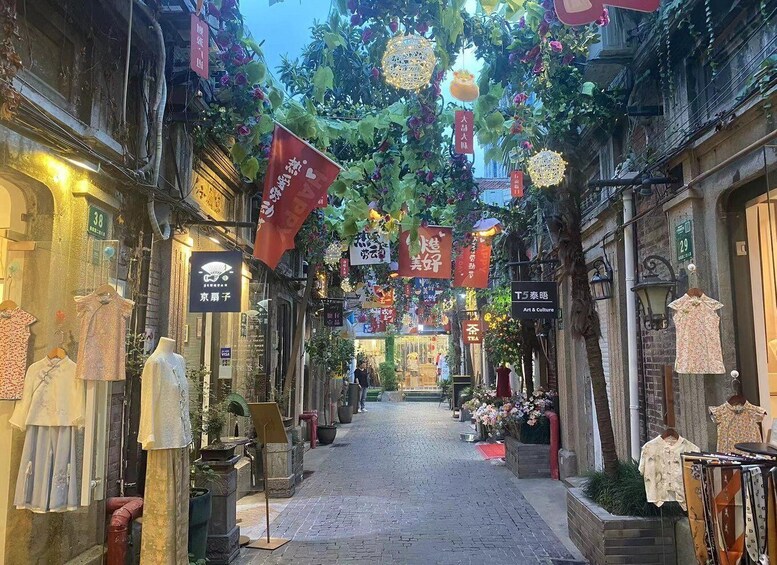 A narrow street lined with shops and hanging decorations. 2